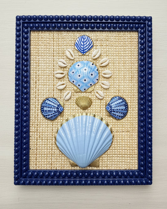 Decorative wall art with blue and gold shell designs on a woven background, framed in blue.